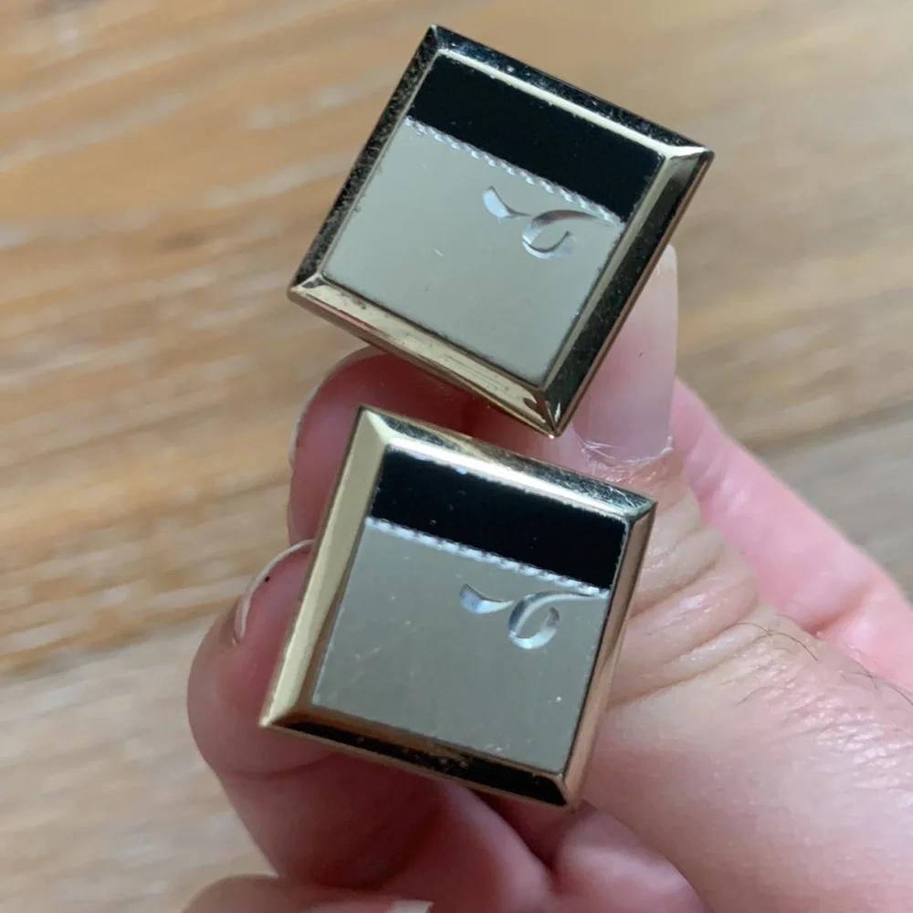 gold cuff links with silver and black accents